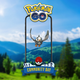 Starly hovers inside the POGO Community Day frame, against a background of trees, hills, and sky.